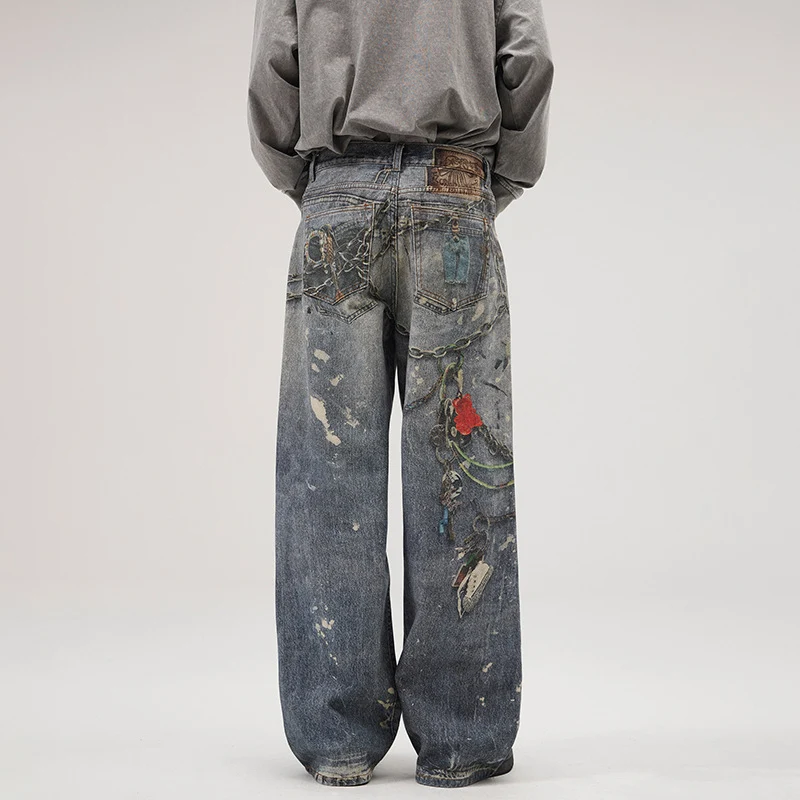 Herren Weit geschnittene Stonewashed-Denim-Jeans mit Kettenprint, Farb‑Splatter und bodenlangem Saum Nord Taschen